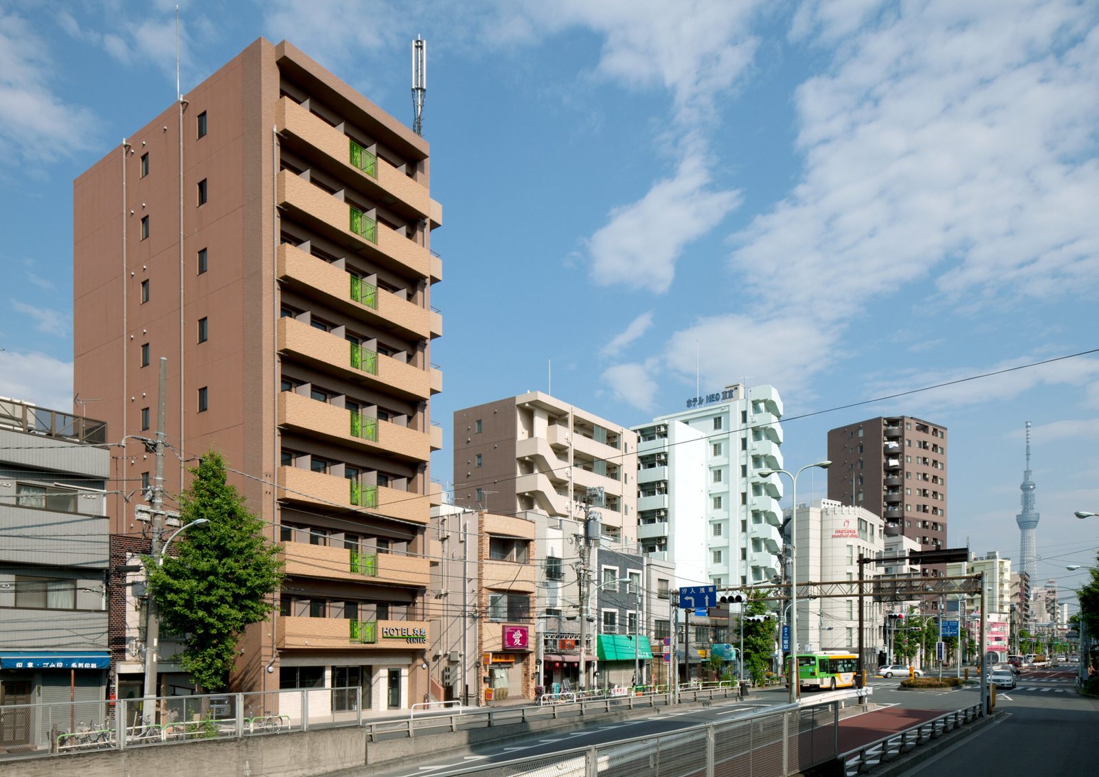 ホテル丸忠 CENTRO の外観。隅田川沿いの南千住の街並みとスカイツリー